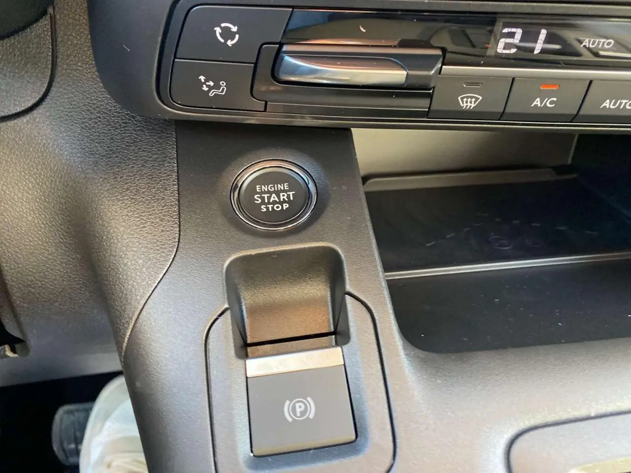 Détail intérieur du tableau de bord du Citroën Berlingo 2025 montrant le bouton start/stop et la commande de frein à main électrique.