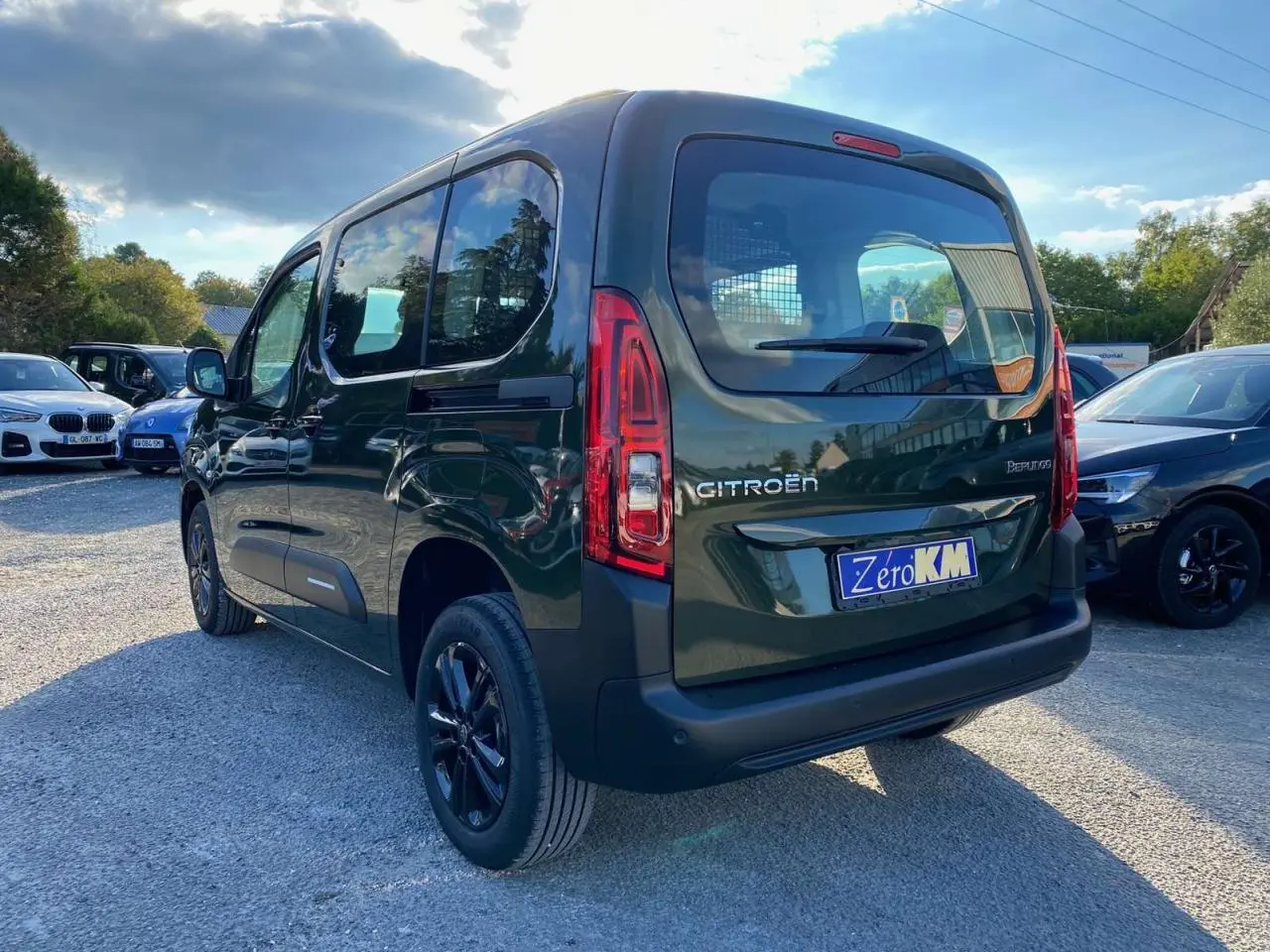 Vue 3/4 arrière droite du Citroën Berlingo 2025 vert Sirka avec jantes alliage et caméra de recul visible.
