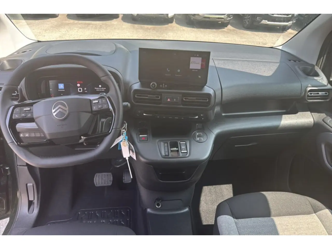 Vue intérieure du tableau de bord du Citroën Berlingo 2025, avec volant multifonction et écran tactile central.