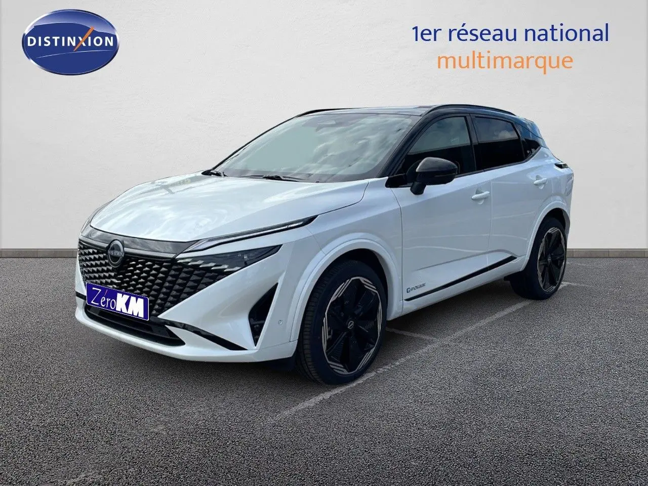 Nissan Qashqai 2025 blanc nacré et toit noir, vue 3/4 avant droit mettant en valeur sa calandre noire distinctive.