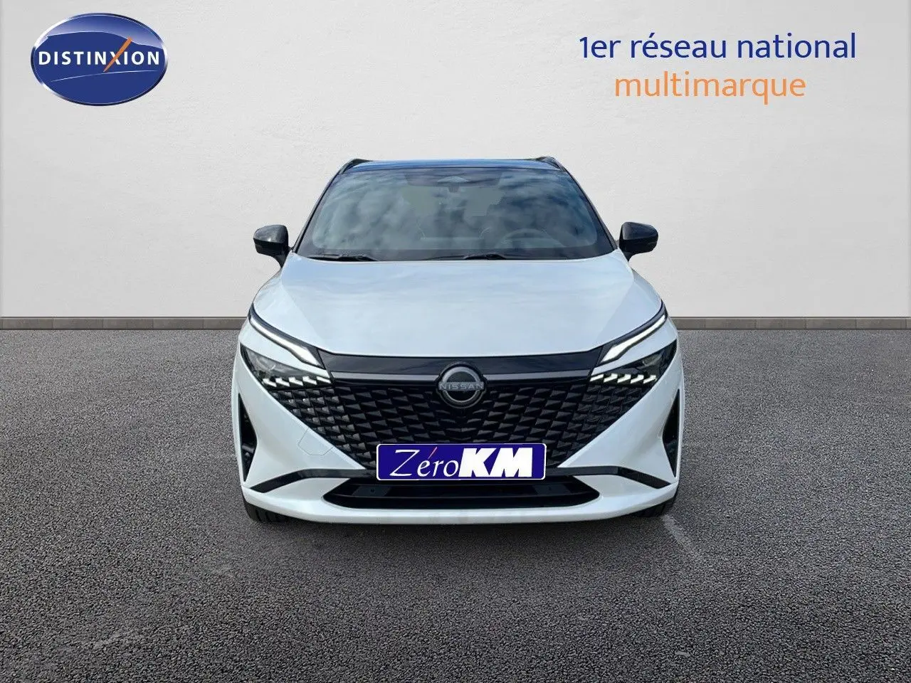 Vue frontale d'un Nissan Qashqai blanc nacré avec toit noir, calandre noire et phares LED modernes.