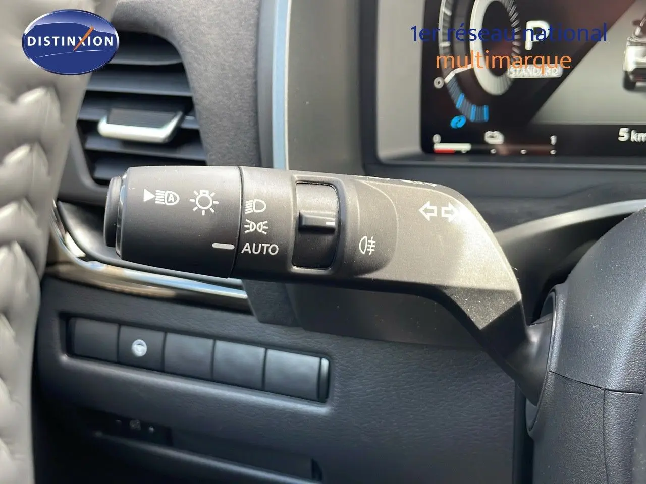 Gros plan sur la manette de commande des phares et clignotants dans l'habitacle du Nissan Qashqai blanc nacré 2025.