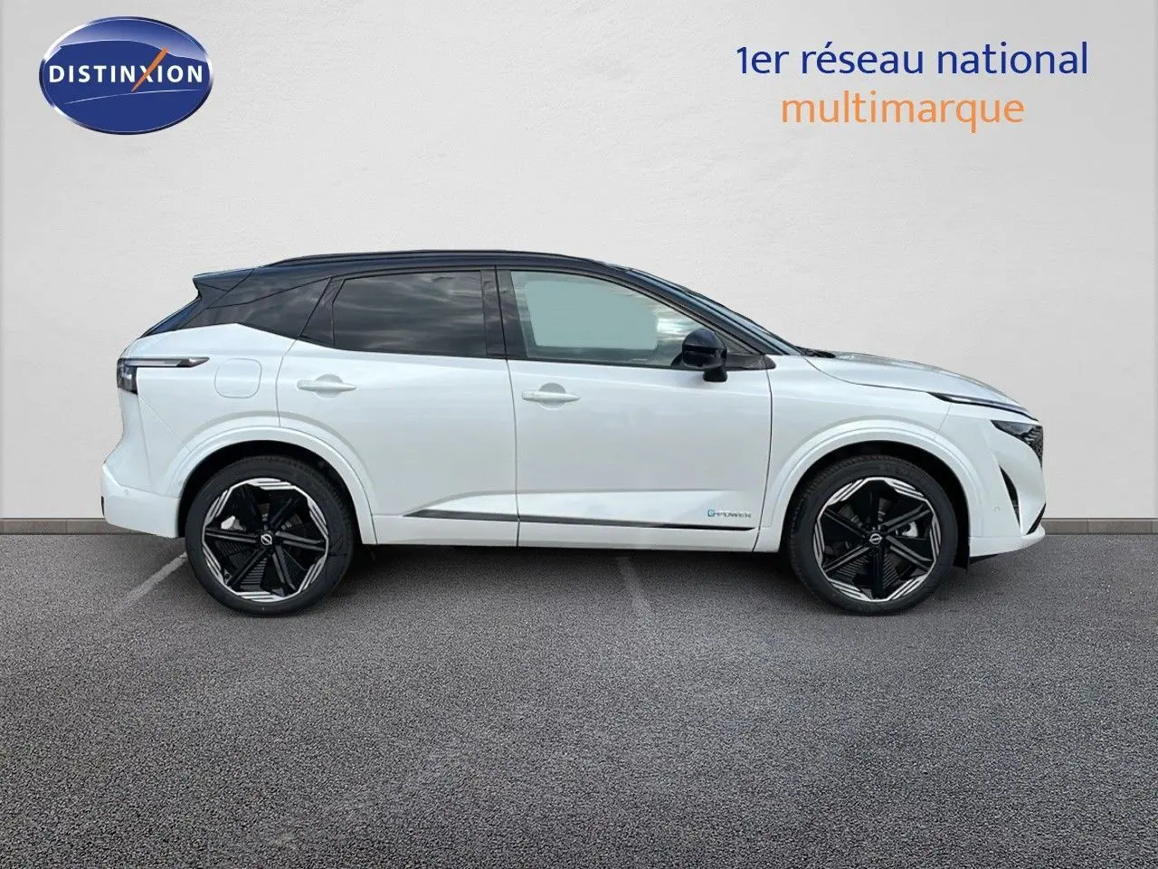 Profil droit du Nissan Qashqai 2025 blanc nacré avec toit noir et jantes noires distinctives.