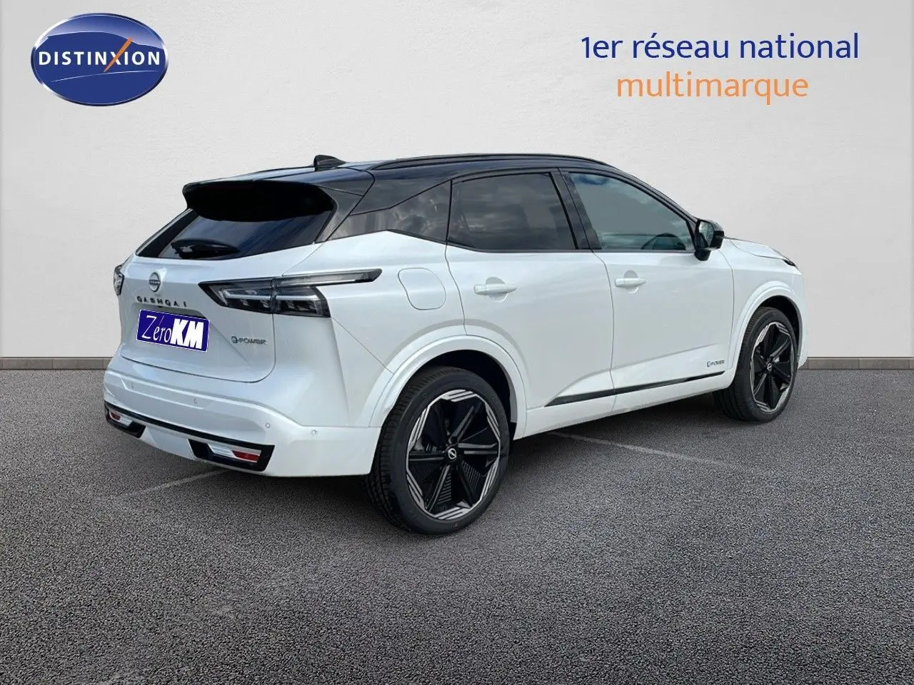 Nissan Qashqai 2025 blanc nacré métal avec toit noir, vue 3/4 arrière côté droit, jantes noires distinctives.