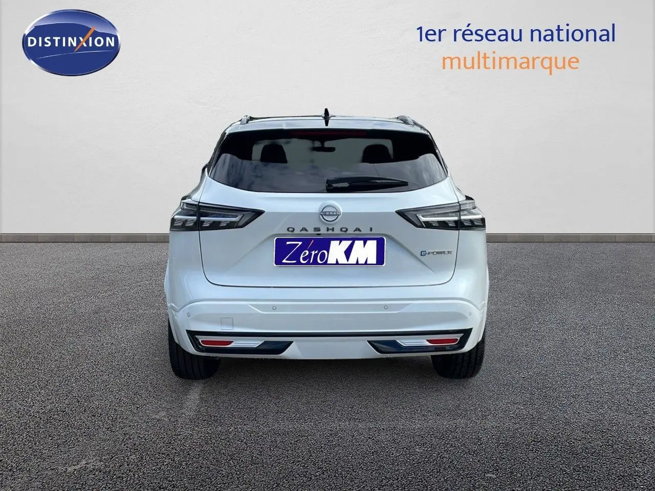 Vue arrière d'un Nissan Qashqai blanc nacré avec toit noir, version hybride e-power 2025, sur fond neutre.