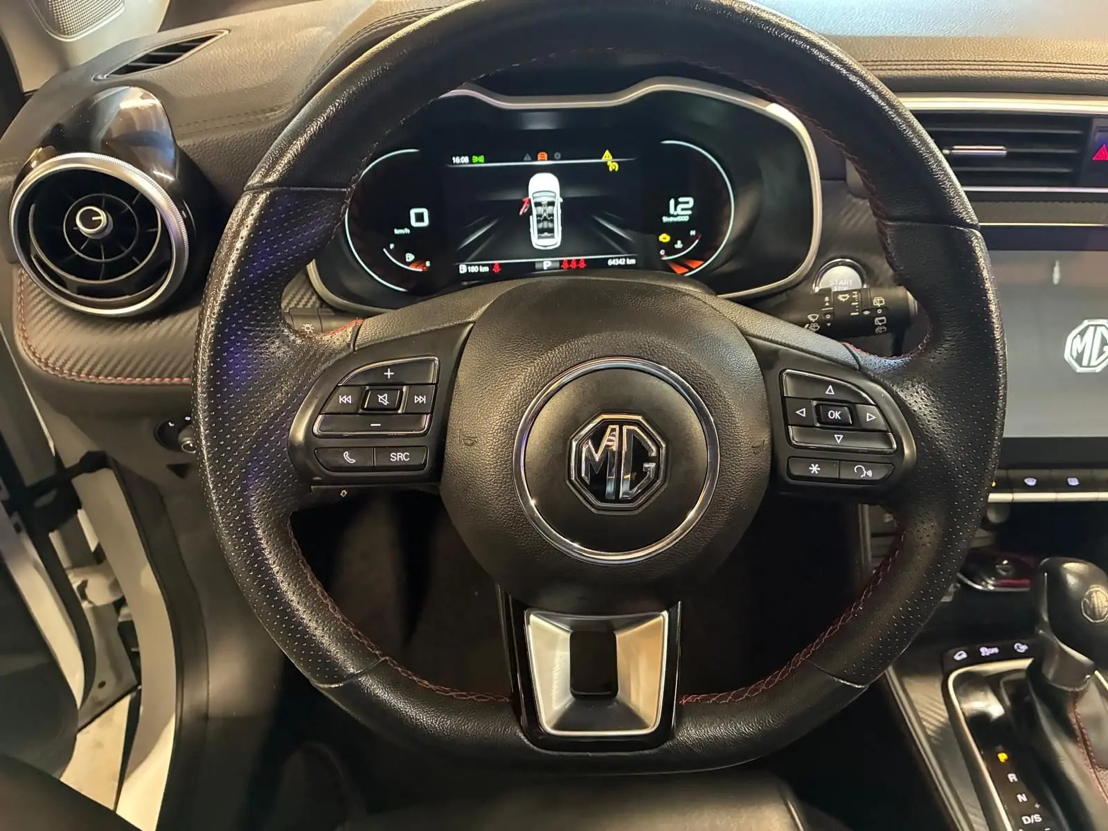 Vue centrée sur le volant en cuir noir du MG ZS 2022 avec tableau de bord numérique et console centrale visible.