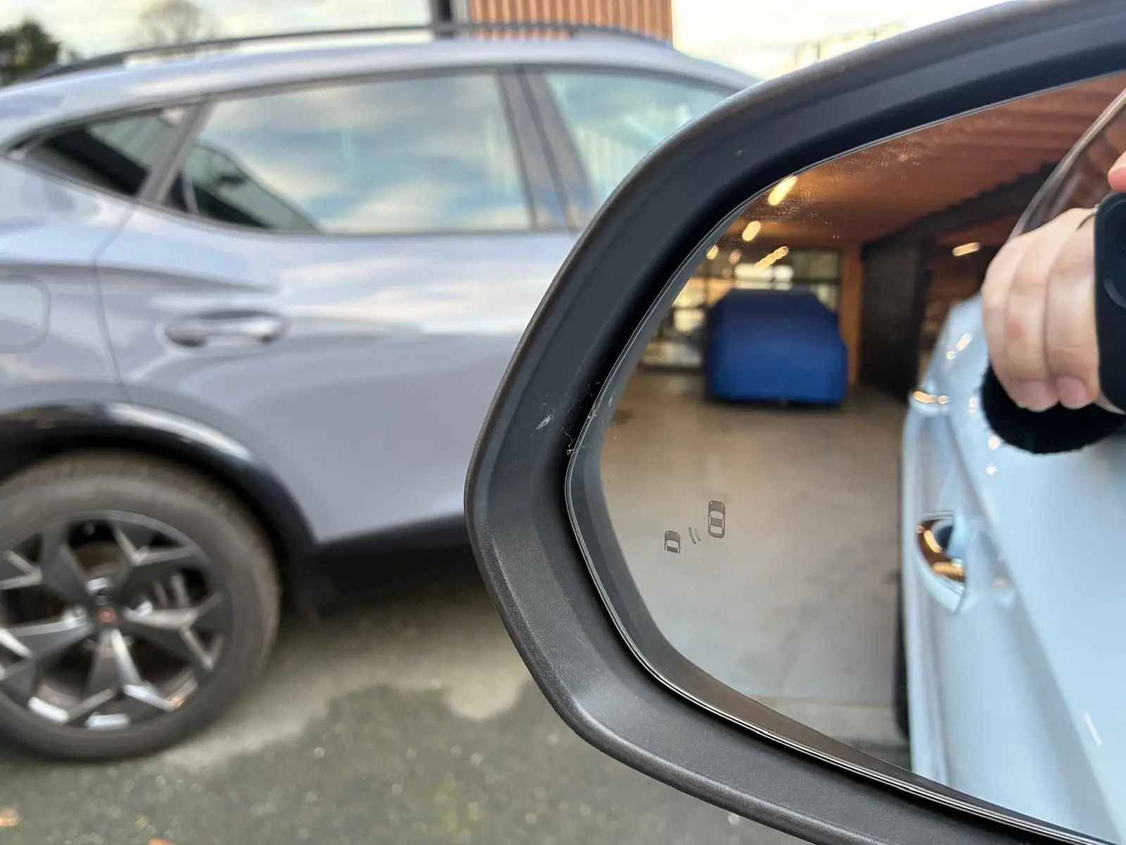 Rétroviseur droit d’un MG ZS blanc 2022 montrant la carrosserie et la roue arrière noire en arrière-plan.