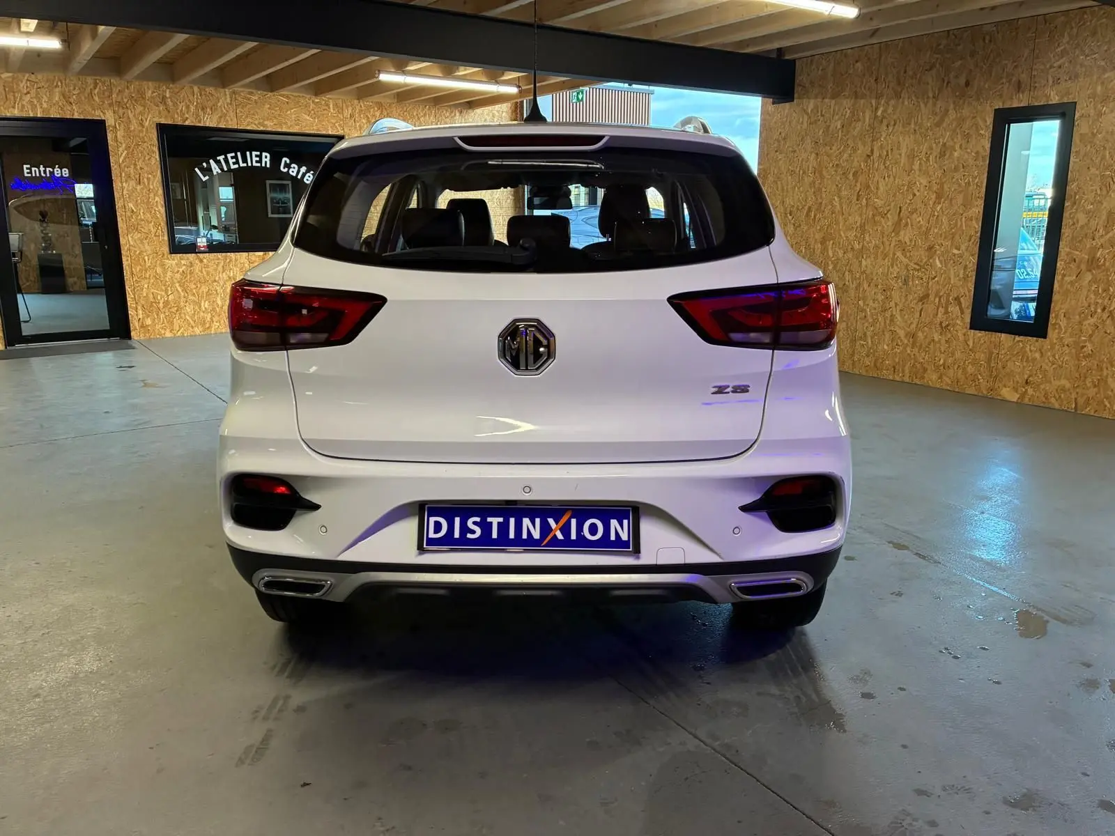 Vue arrière d’un MG ZS blanc 2022 en version Luxury, avec feux rouges et double sortie d’échappement visible.