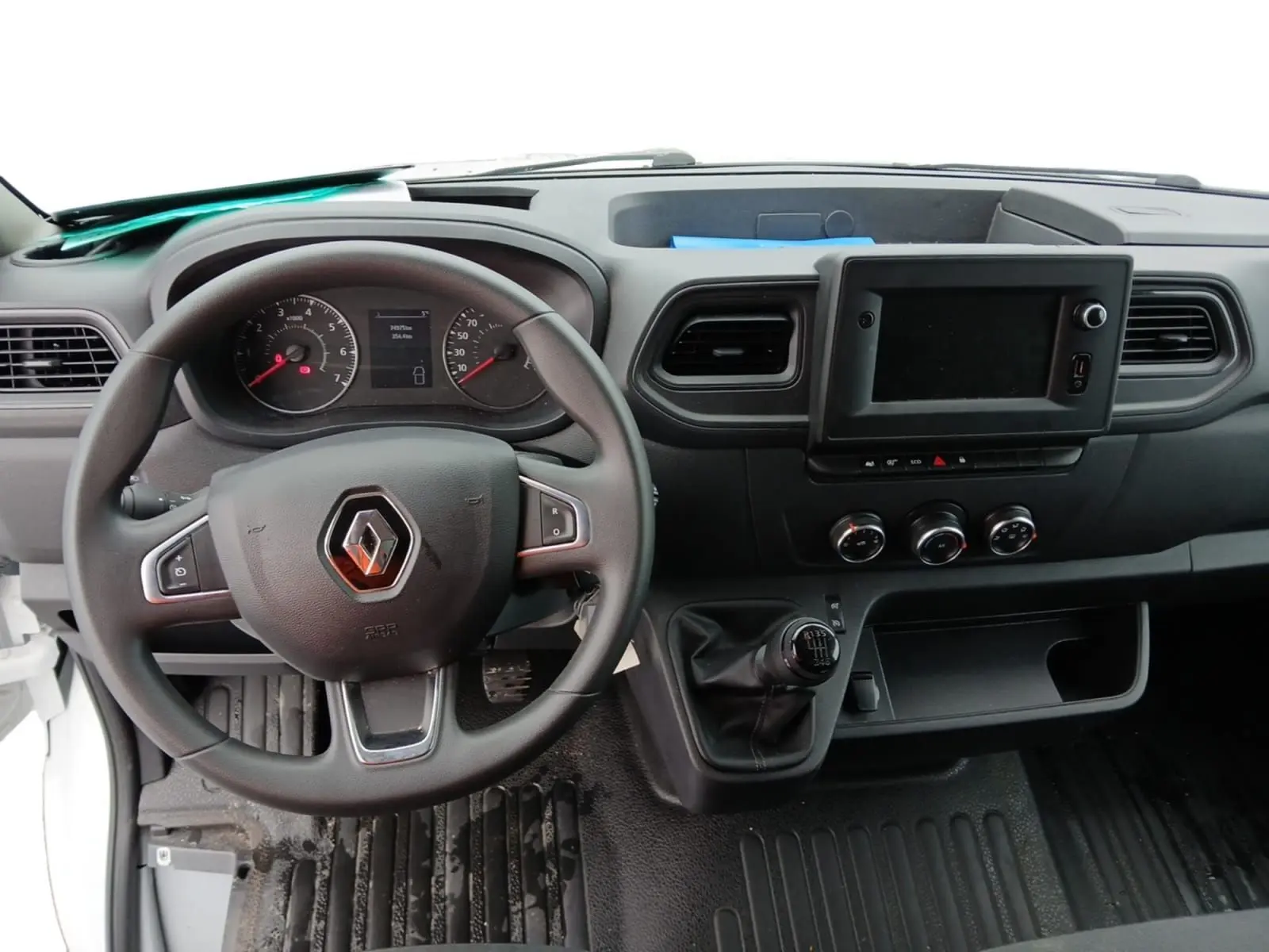 Vue intérieure du tableau de bord du Renault Master 2023, avec volant, levier de vitesses manuel et écran central noir.