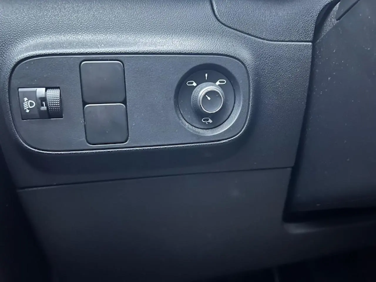 Détail des commandes de réglage des rétroviseurs et de l'éclairage sur la planche de bord noire d'une Citroën C3 Shine 2023.