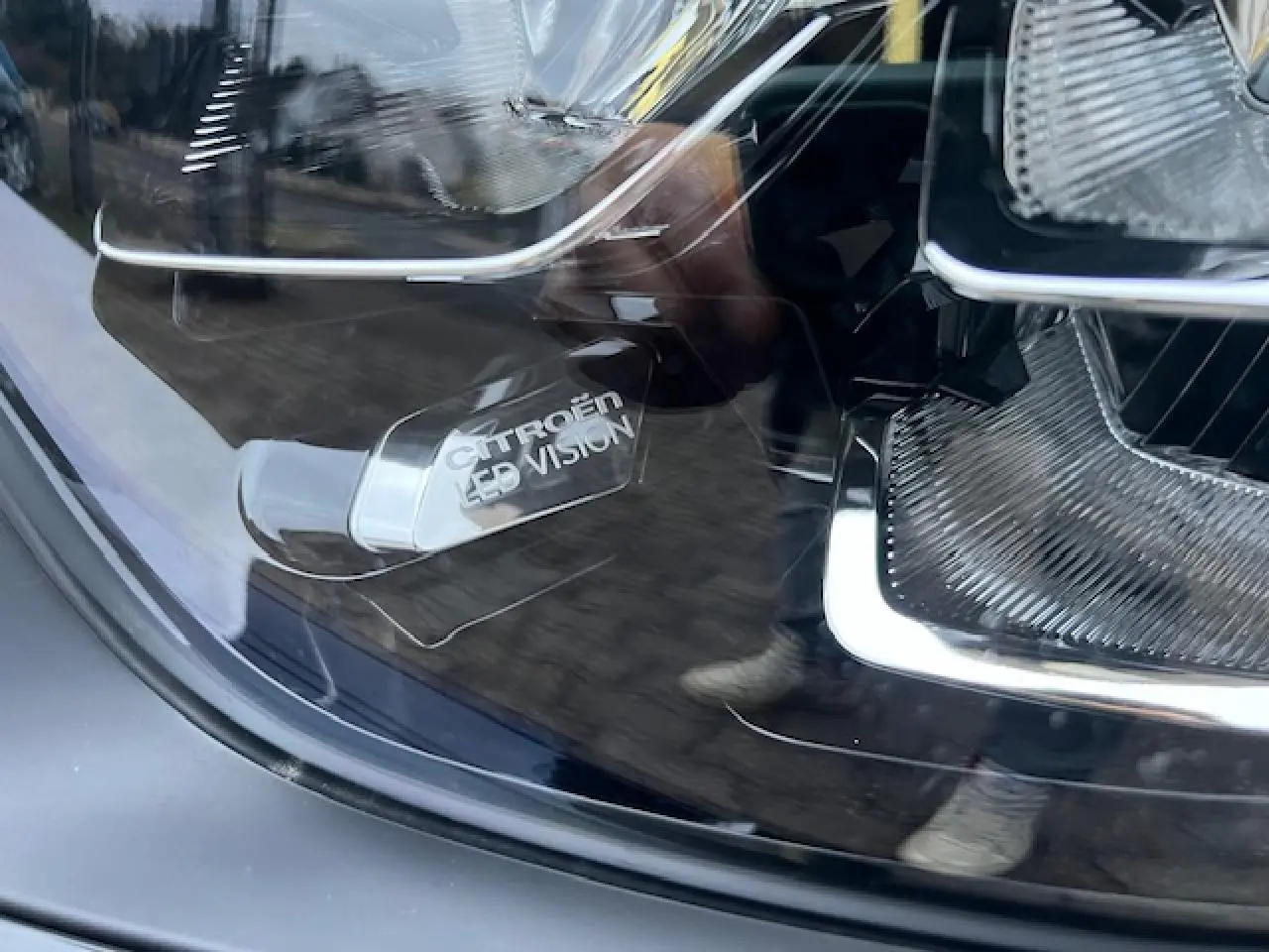 Gros plan sur le projecteur avant LED d'une Citroën C3 Shine 2023 noir toit rouge avec inscription LED Vision.