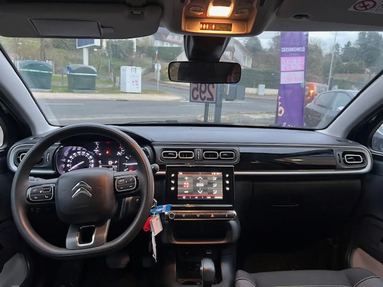 Vue intérieure avant de la Citroën C3 Shine 2023, tableau de bord noir avec écran tactile central et volant multifonction.