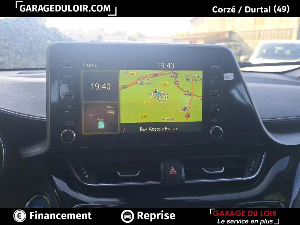 Vue rapprochée de l’écran tactile central du Toyota C-HR 2023 affichant la navigation et l’heure, intérieur noir.