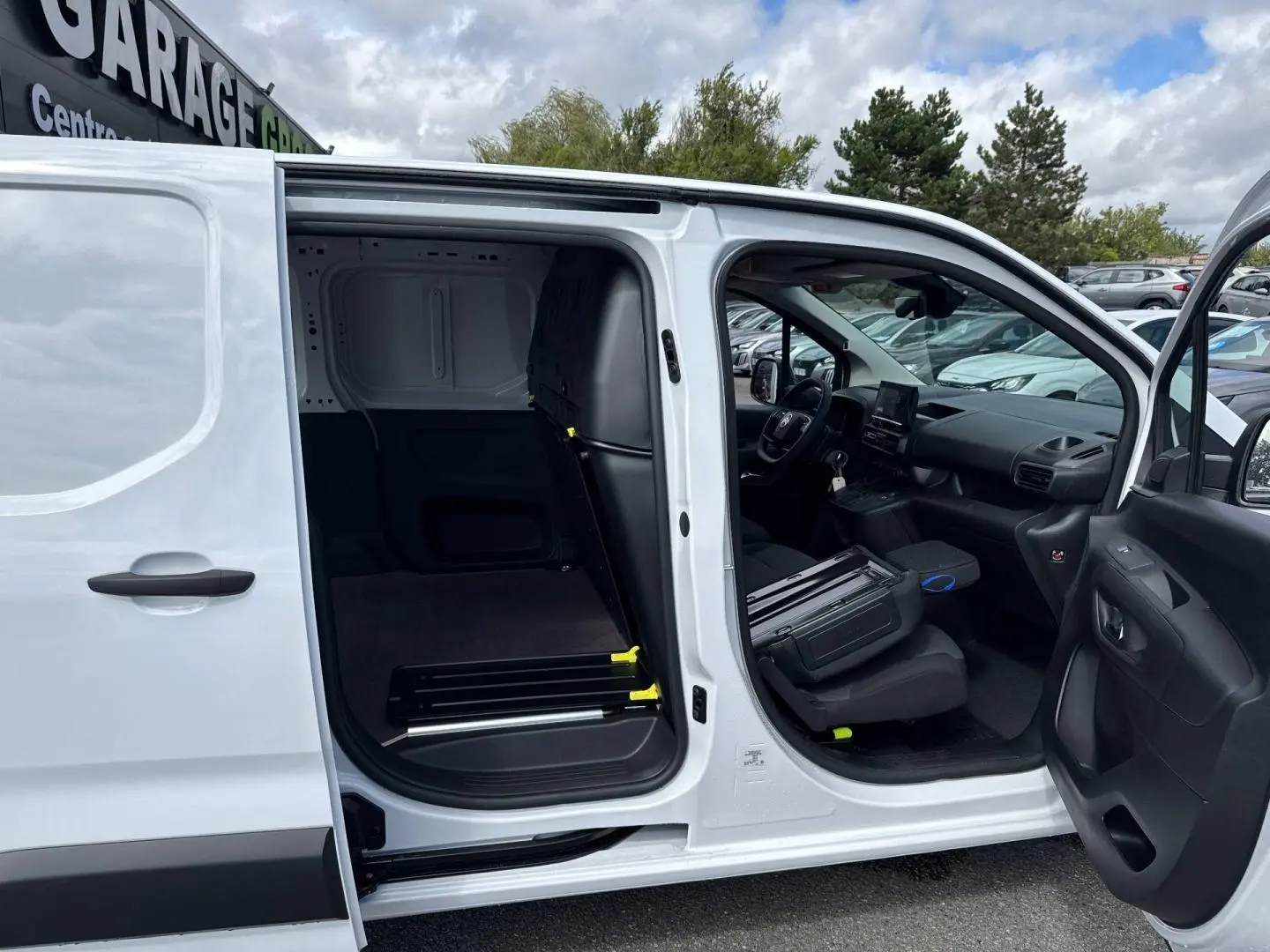 Vue latérale droite d’un Citroën Berlingo Fourgon XL blanc Icy avec portes ouvertes montrant l’intérieur utilitaire vide.