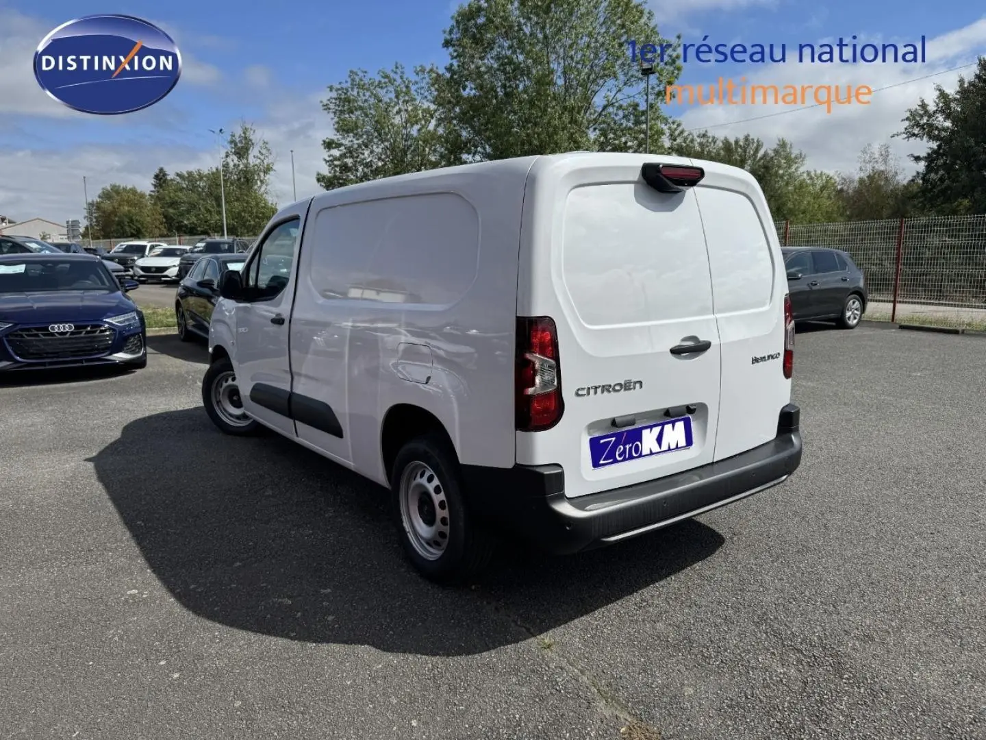 Vue 3/4 arrière droite du Citroën Berlingo Fourgon XL blanc Icy avec portes arrière fermées sur parking.