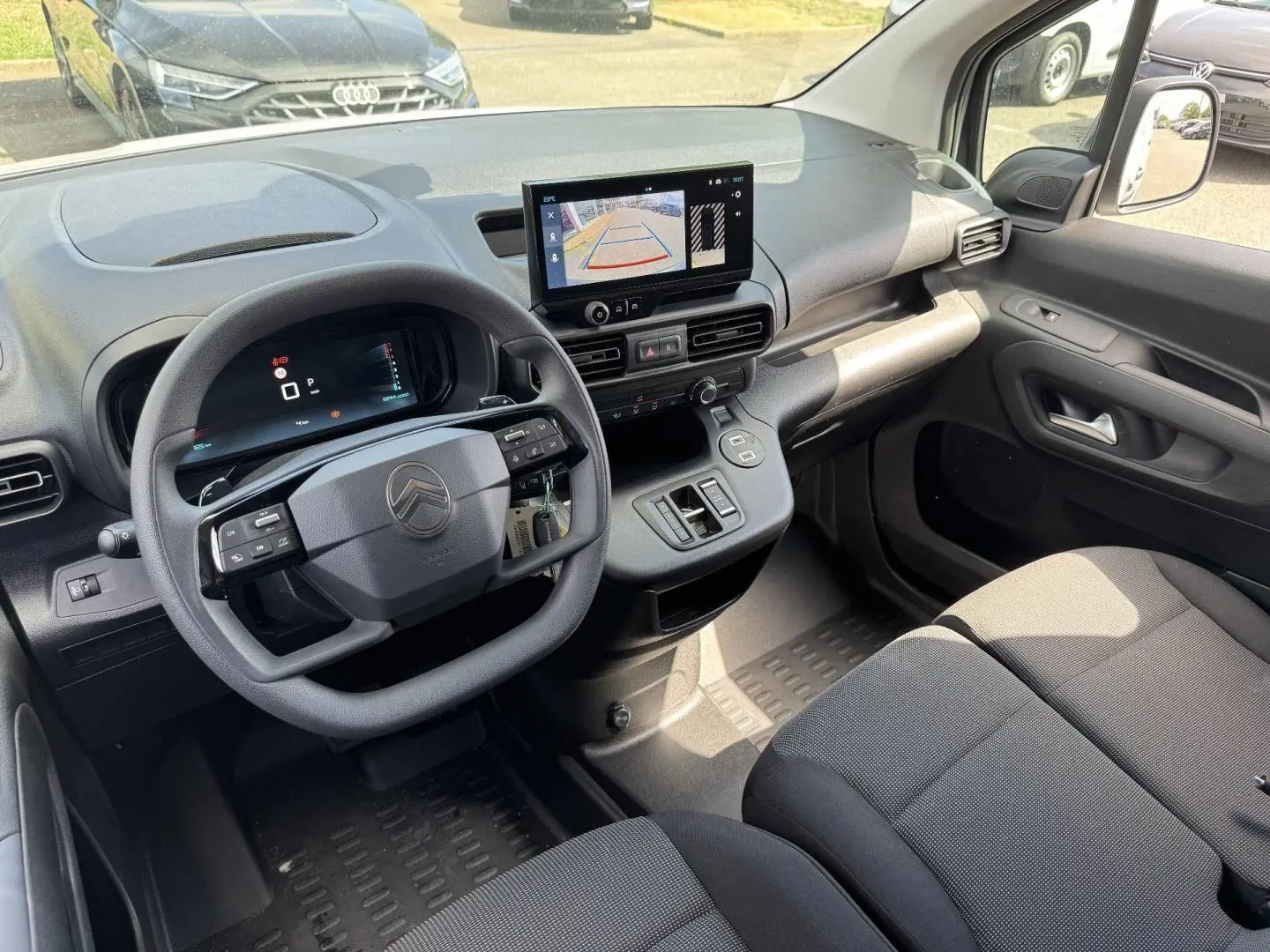 Vue intérieure côté conducteur du Citroën Berlingo Fourgon XL Diesel 130ch, tableau de bord avec écran tactile et volant multifonction.