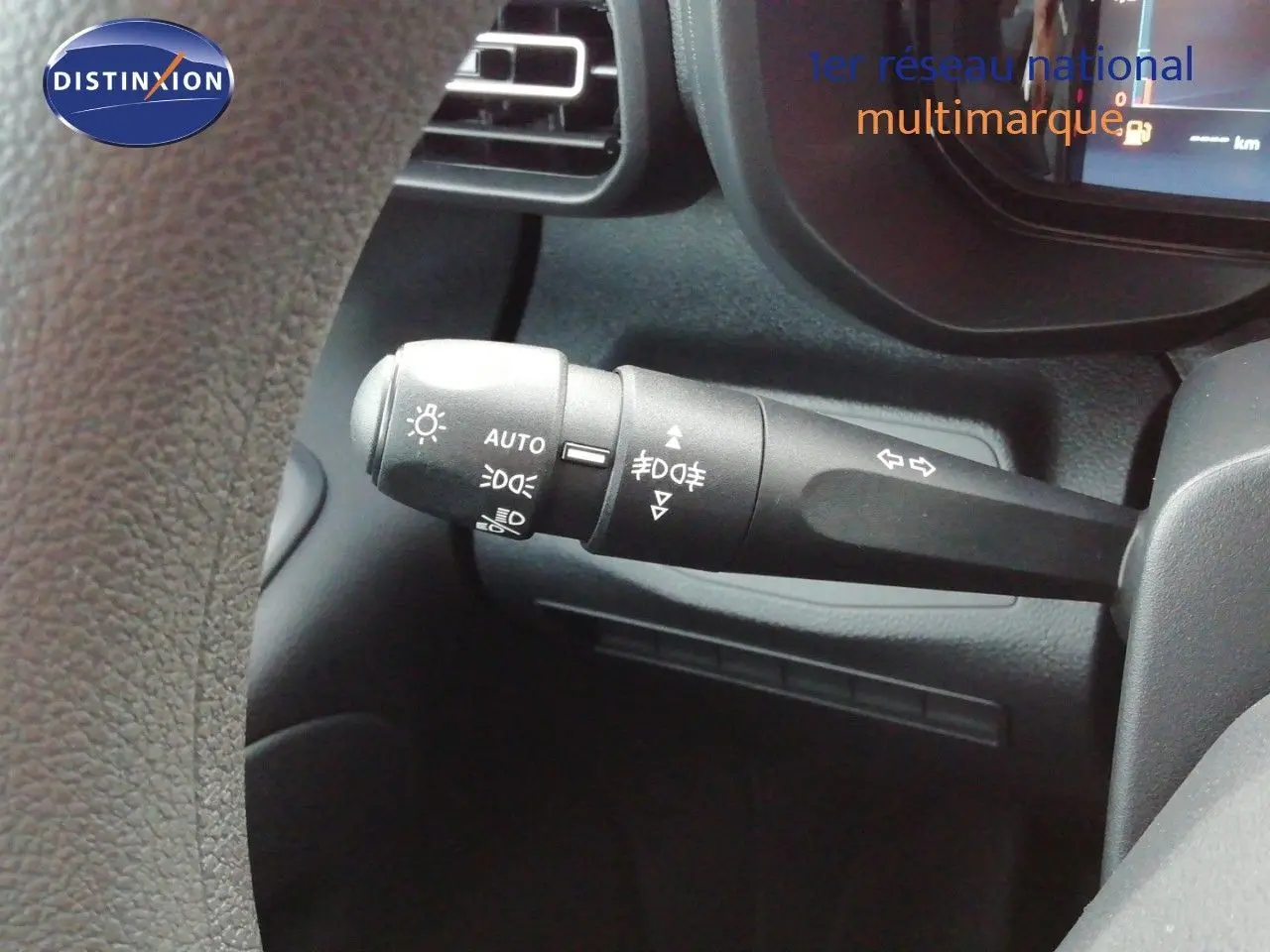 Gros plan sur la manette de commande d’éclairage à gauche du volant dans l’habitacle du Citroën Berlingo blanc Icy 2026.
