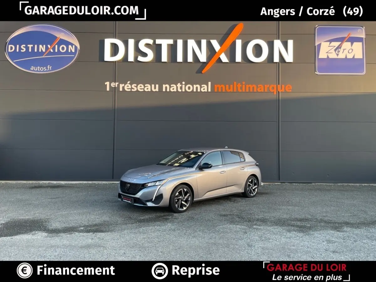 Peugeot 308 gris foncé vue 3/4 avant droit, stationnée devant un mur avec logo Distinxion en arrière-plan.