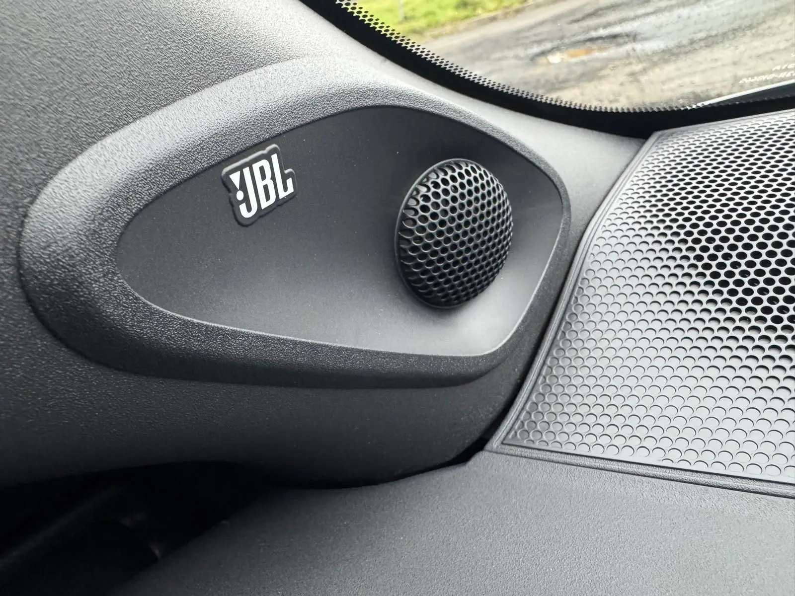 Gros plan sur l'enceinte JBL intégrée dans l'habitacle de la Toyota Yaris GR Pack Techno, finition noire.
