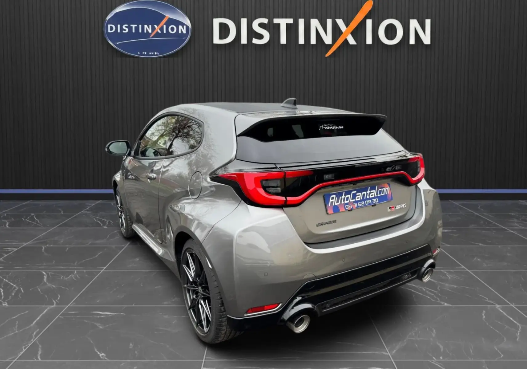 Vue 3/4 arrière droite de la Toyota Yaris GR gris platine avec toit carbone, jantes BBS noires et double sortie d'échappement.