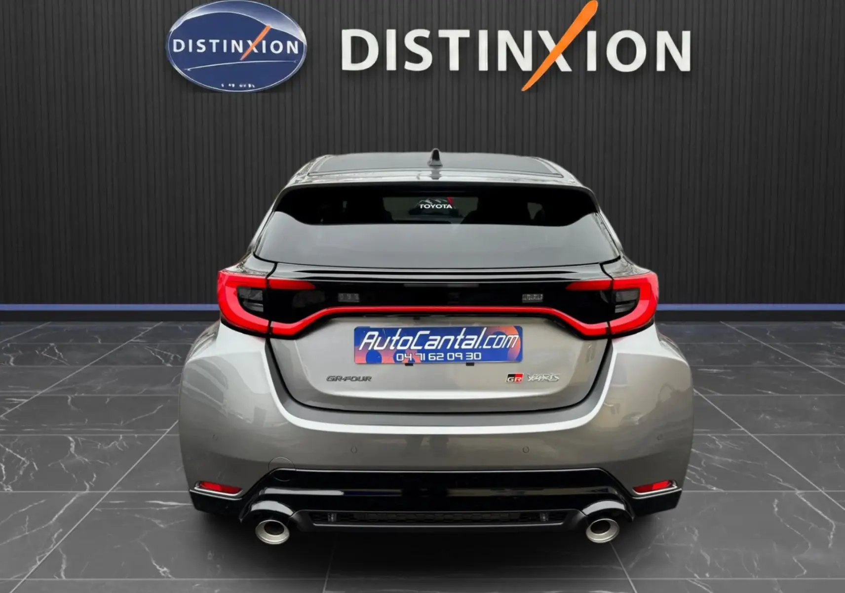 Vue arrière d'une Toyota Yaris GR Pack Techno gris platine avec feux rouges en forme de C et double sortie d'échappement chromée.