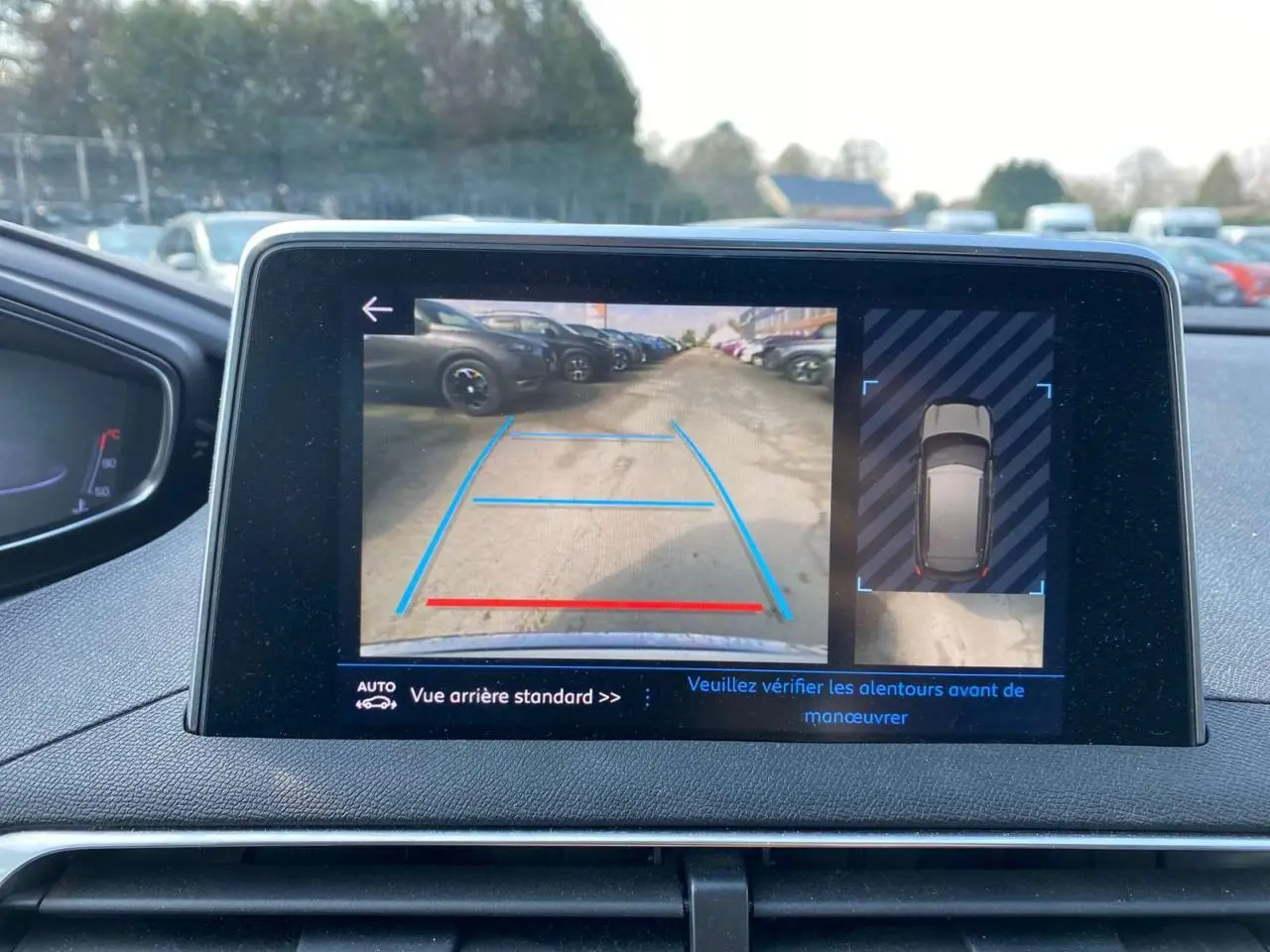 Écran central du Peugeot 3008 blanc montrant la caméra de recul avec aide au stationnement et vue 360° du véhicule.