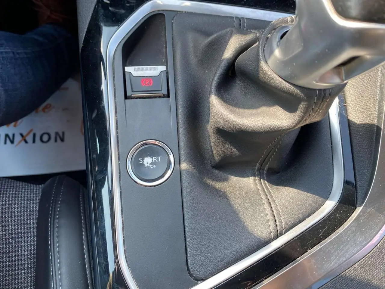 Gros plan intérieur sur la console centrale noire avec levier de vitesse manuel et bouton start/stop du Peugeot 3008 blanc.