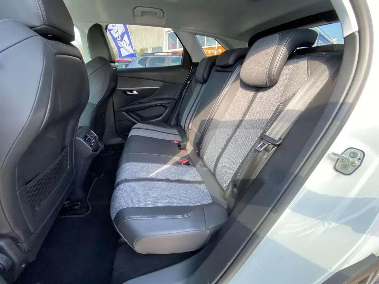 Vue intérieure côté droit sur la banquette arrière bi-matière grise et noire du Peugeot 3008 blanc de 2018.