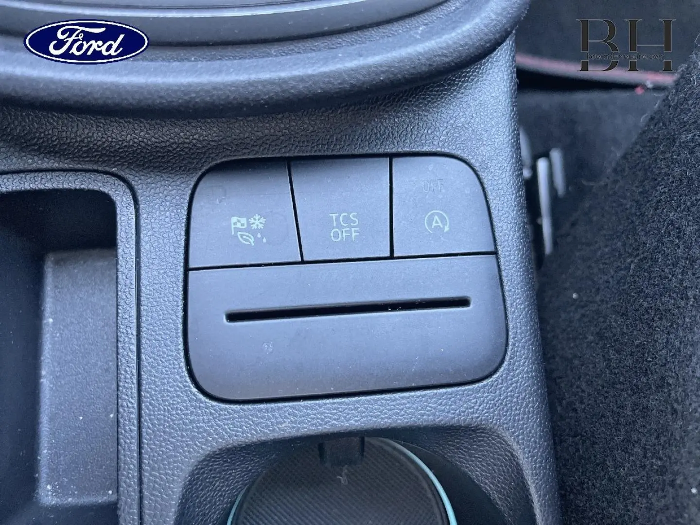Gros plan sur les boutons de commande au centre de la console d’une Ford Puma 2022 gris Solar métallisée.