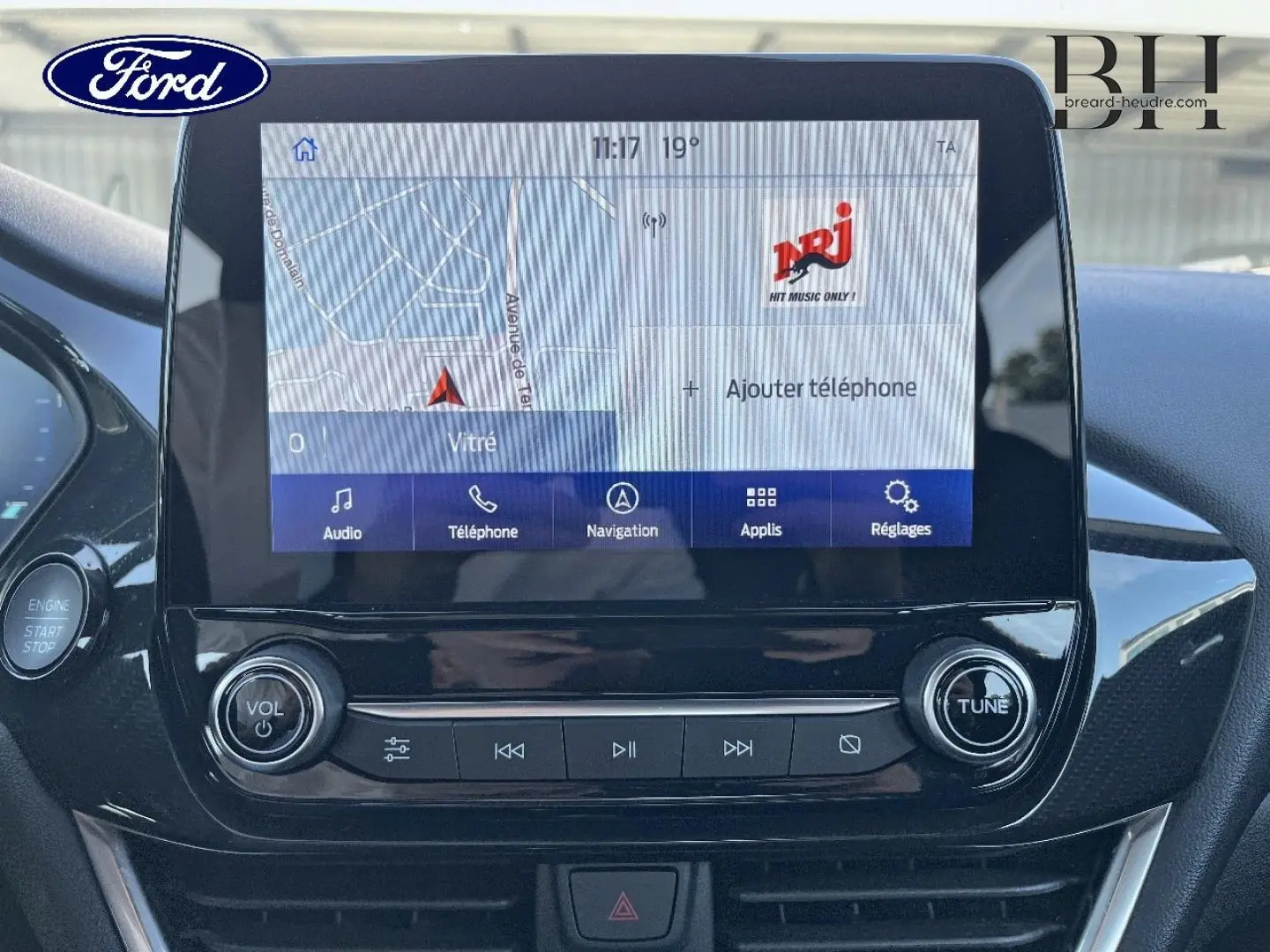 Vue rapprochée de l’écran tactile central et des commandes audio d’un Ford Puma gris Solar métallisé, intérieur noir brillant.