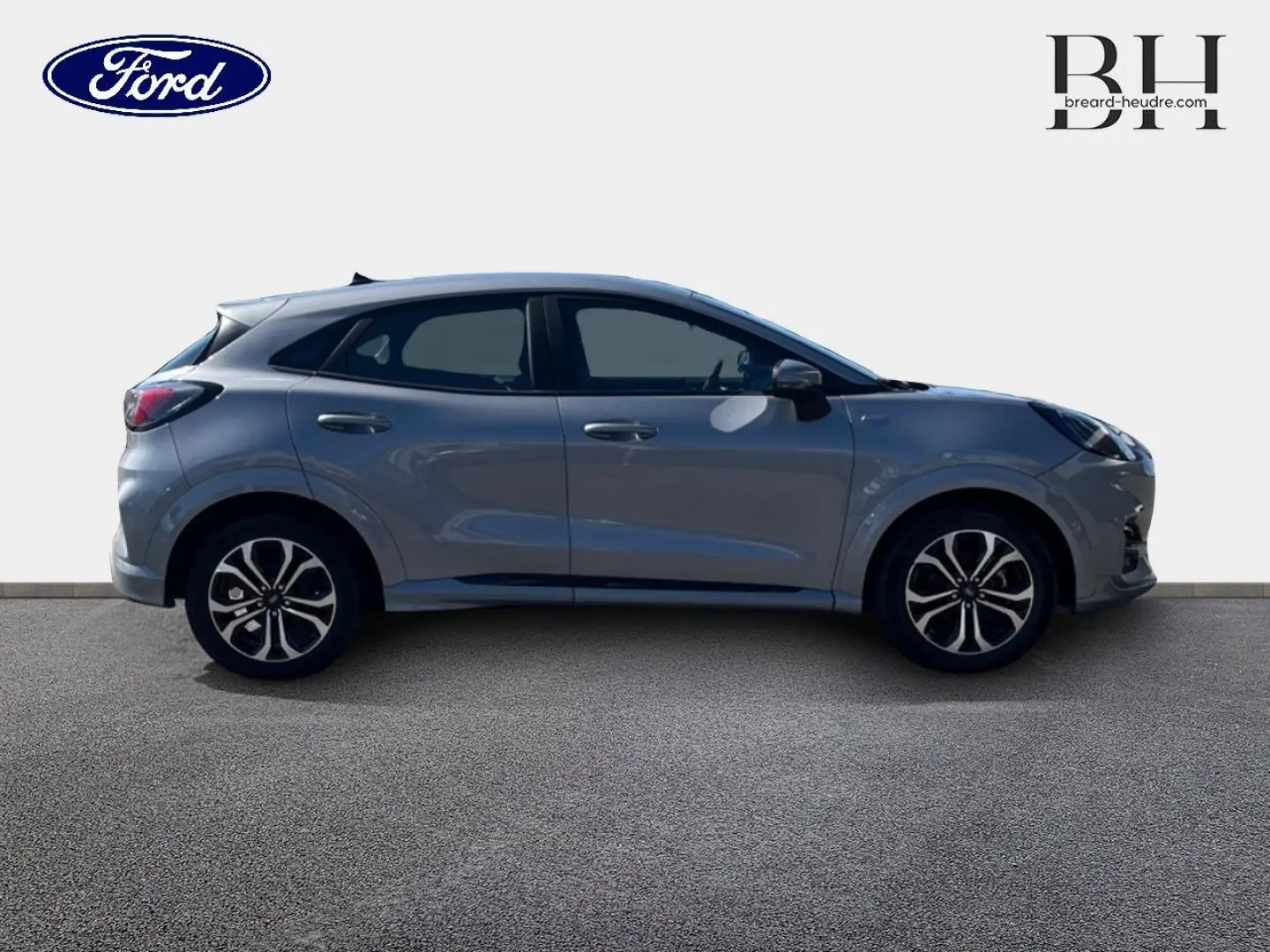 Vue de profil côté gauche d'un Ford Puma 2022 gris Solar métallisé avec jantes alliage et vitres teintées.