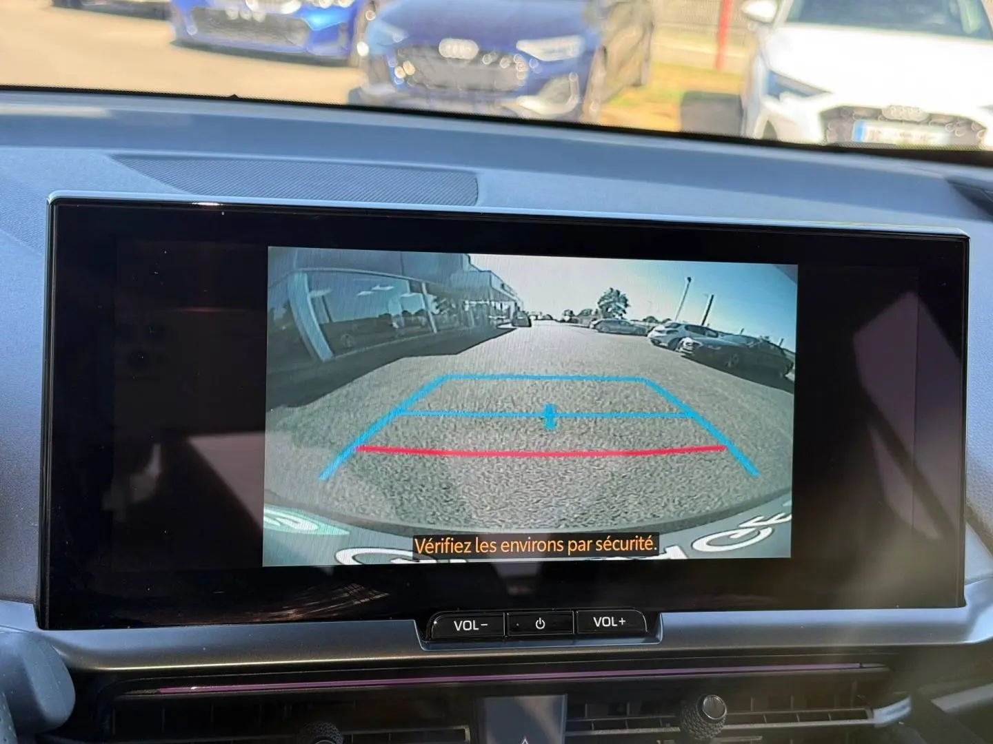 Vue de l'écran de caméra de recul du Toyota C-HR 2.0 Hybride gris Atlas, affichant les lignes de guidage en bleu et rouge.