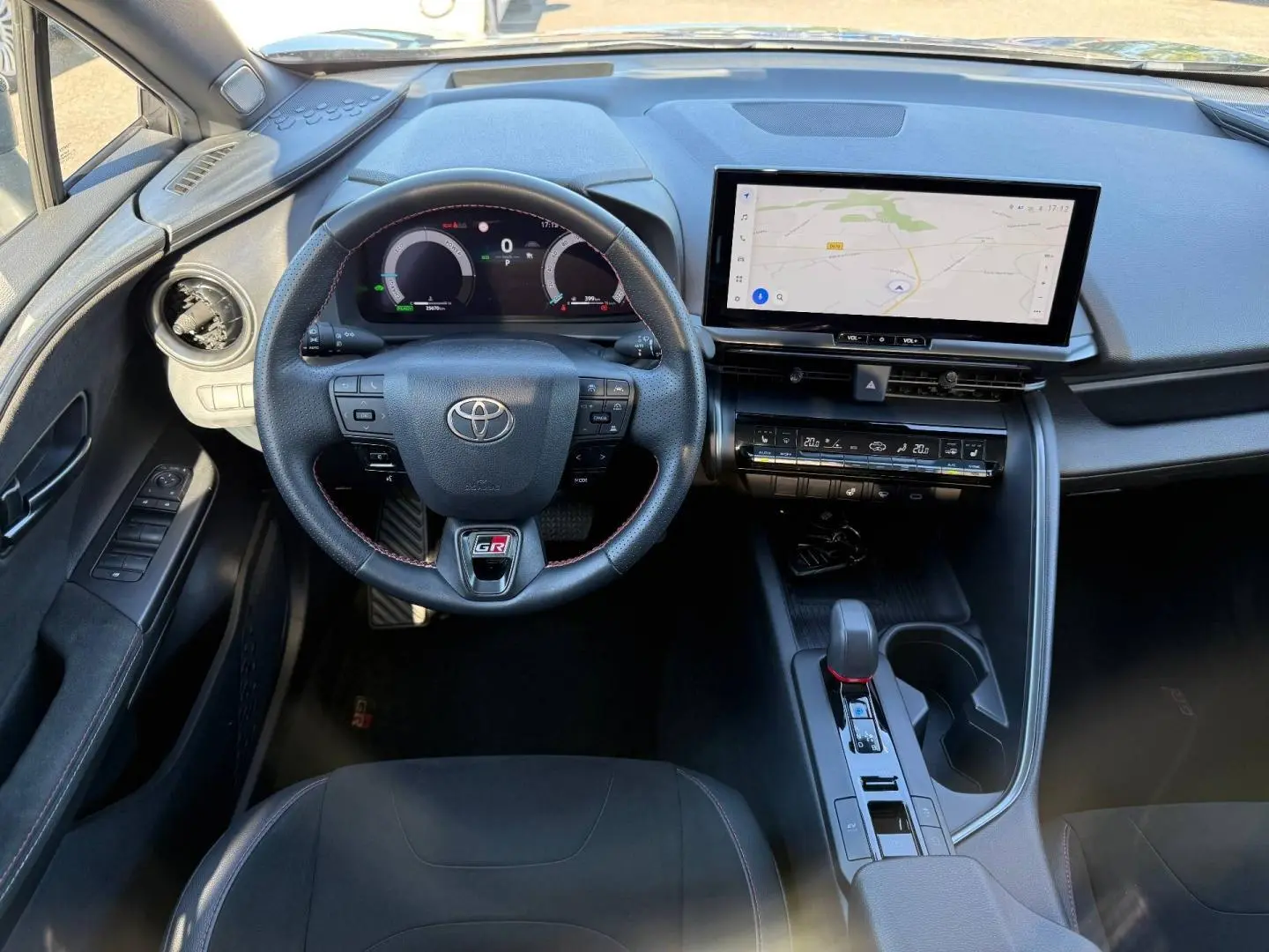 Vue intérieure avant du Toyota C-HR GR Sport 2025, volant sport noir avec logo GR et écran tactile GPS.