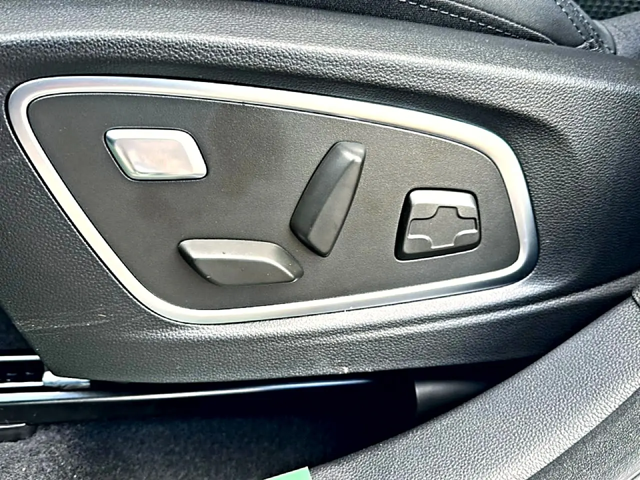 Gros plan sur les commandes électriques de réglage du siège en cuir noir du Renault Austral 2026 esprit alpine.
