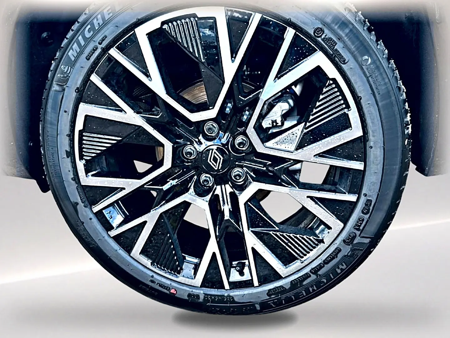 Gros plan sur la jante alu noire et argentée du Renault Austral 1.2 e-tech full hybrid 200 esprit alpine, détail du pneu Michelin.
