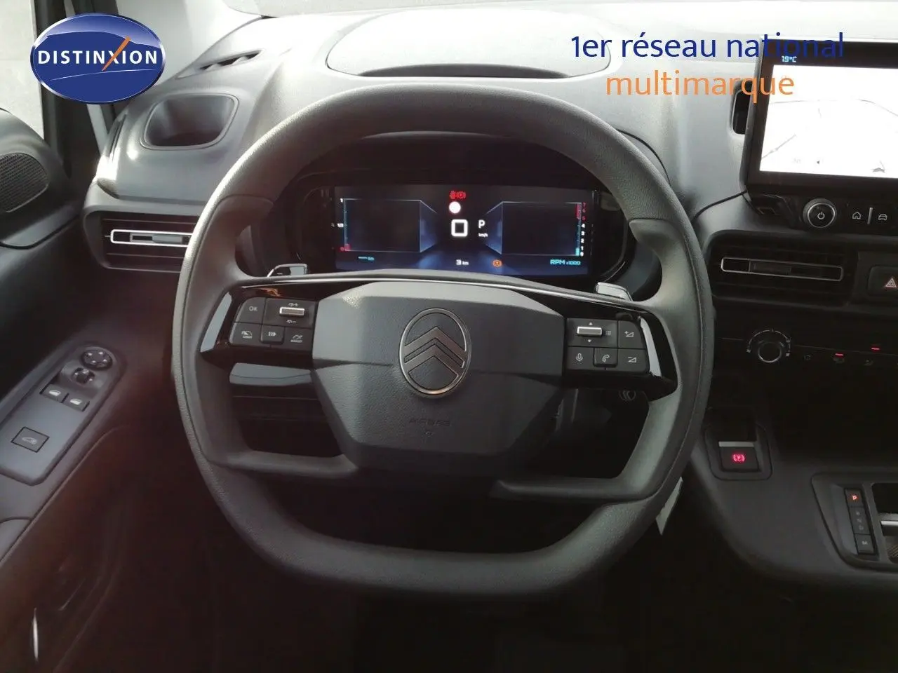 Vue intérieure centrée sur le volant multifonction d’un Citroën Berlingo XL 2026 avec tableau de bord digital.