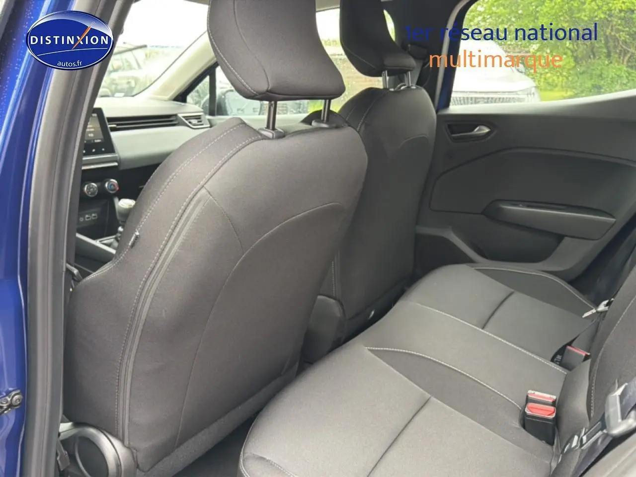Vue intérieure arrière côté gauche de la Renault Clio V Bleu Iron, montrant les sièges arrière et l'avant du véhicule.