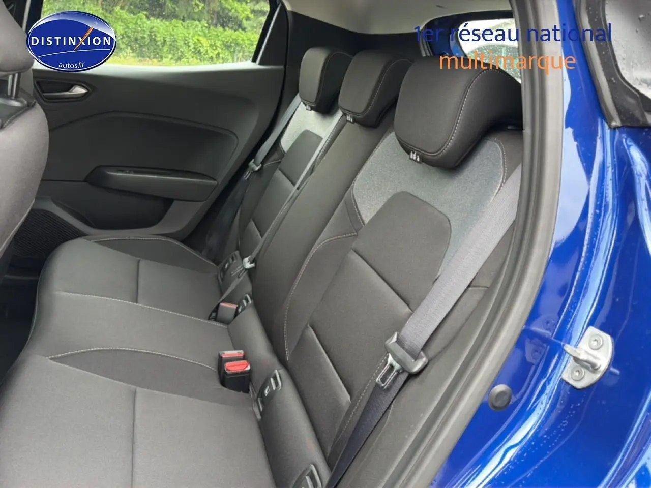 Vue intérieure côté droit sur la banquette arrière noire de la Renault Clio V Bleu Iron avec ceinture de sécurité visible.