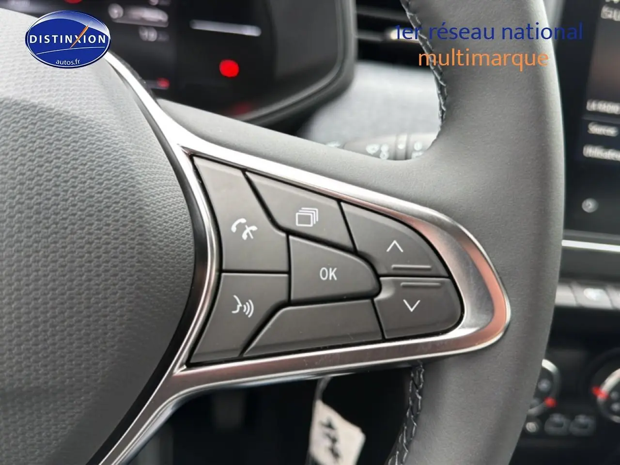 Gros plan sur les commandes multifonctions du volant côté gauche de la Renault Clio V Bleu Iron.