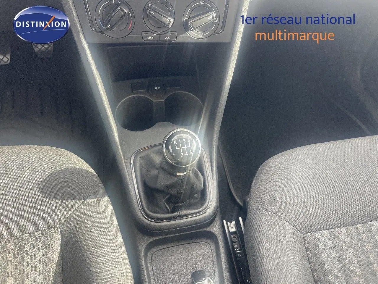 Vue intérieure centrée sur la console centrale d'une Volkswagen Polo noire 2016, mettant en valeur le levier de vitesses manuel.