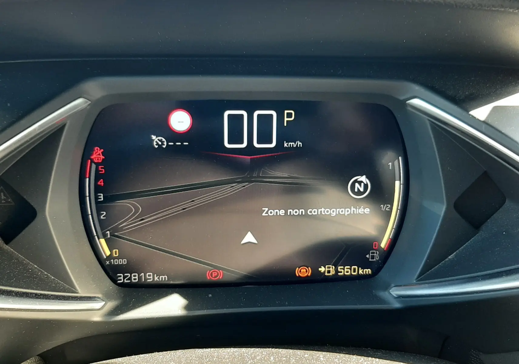 Tableau de bord numérique du DS3 Crossback gris foncé, affichant 0 km/h et une zone non cartographiée.