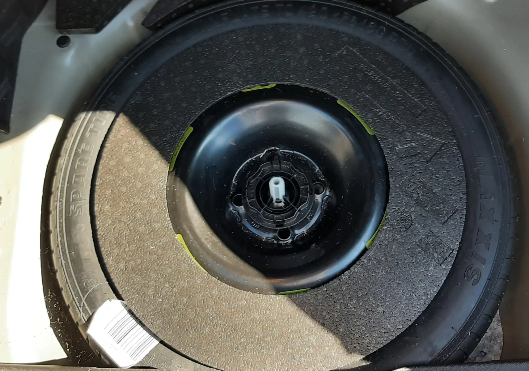 Gros plan sur la roue de secours noire dans le coffre d'un DS3 Crossback gris foncé 2021 diesel