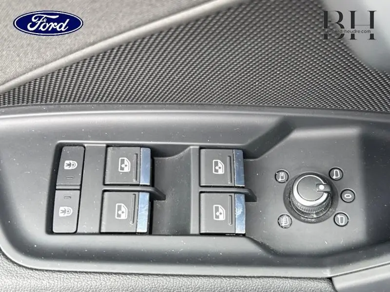 Gros plan sur les commandes des vitres et rétroviseurs côté conducteur d'une Audi A3 Sportback noir Mythic métallisé.