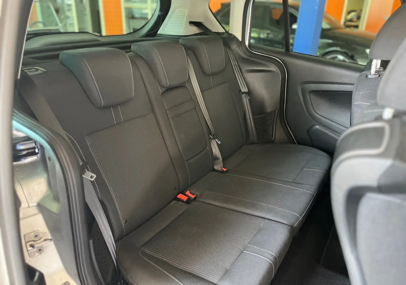 Banquette arrière en tissu noir vue côté gauche d'un Ford B-MAX gris clair 2015 avec ceinture de sécurité visible.