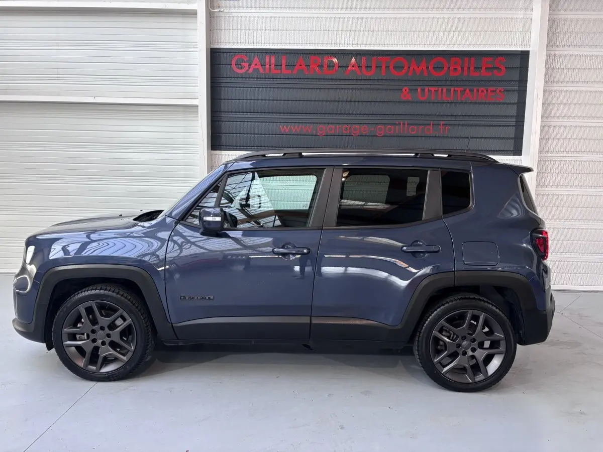 Profil latéral droit d'un Jeep Renegade bleu hybride rechargeable 2021 avec jantes foncées et toit noir.