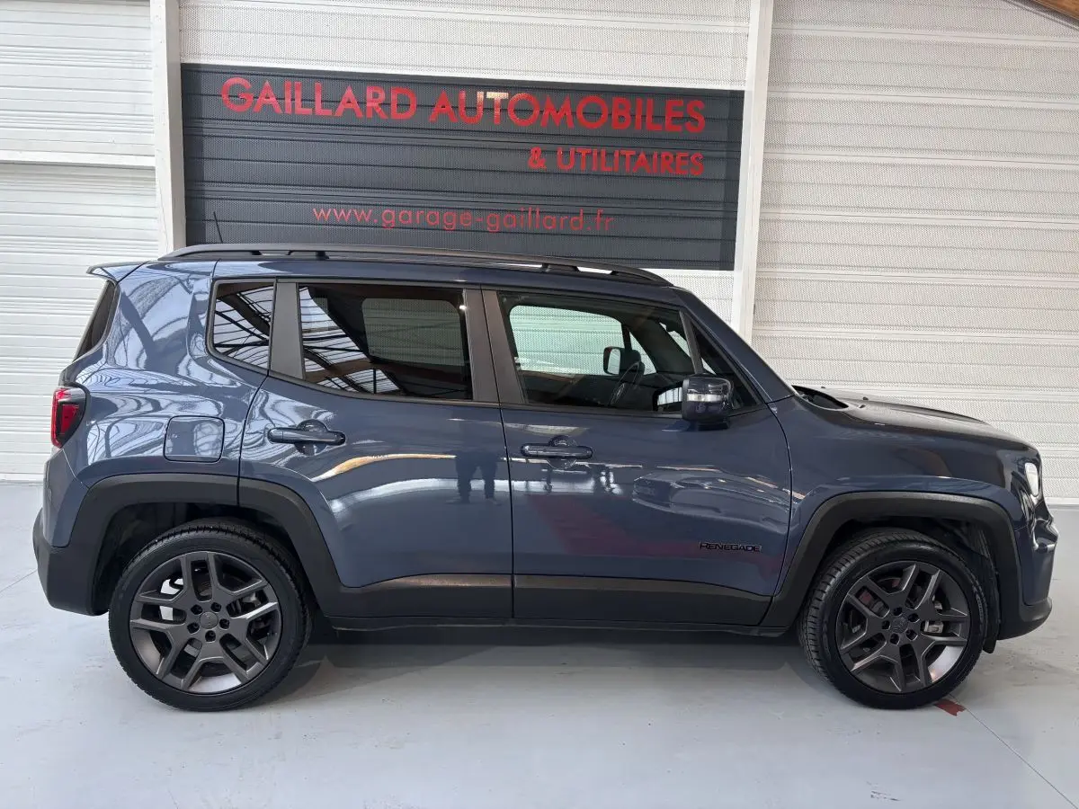 Profil côté gauche d'un Jeep Renegade bleu hybride rechargeable 2021 avec jantes foncées et toit noir.