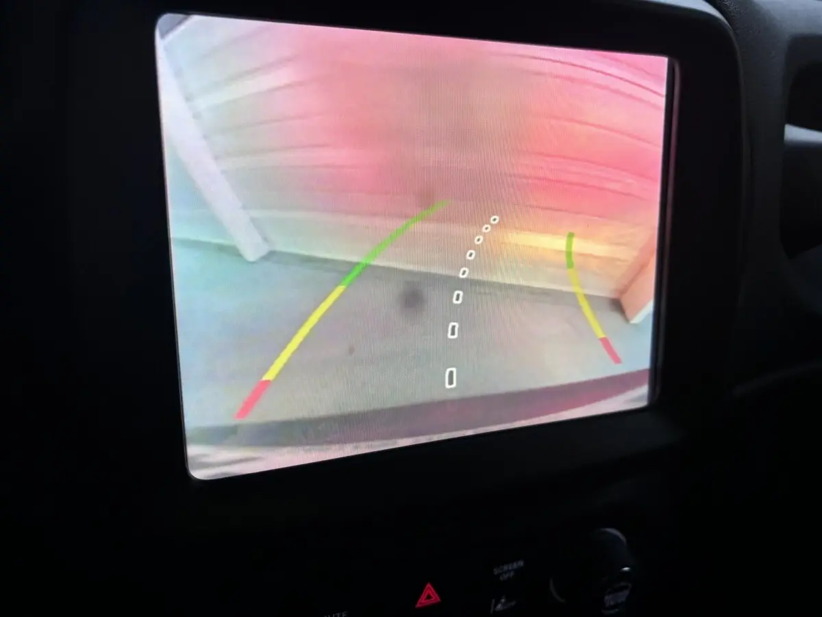 Vue de l'écran de caméra de recul du Jeep Renegade bleu 2021, avec lignes de guidage colorées visibles.