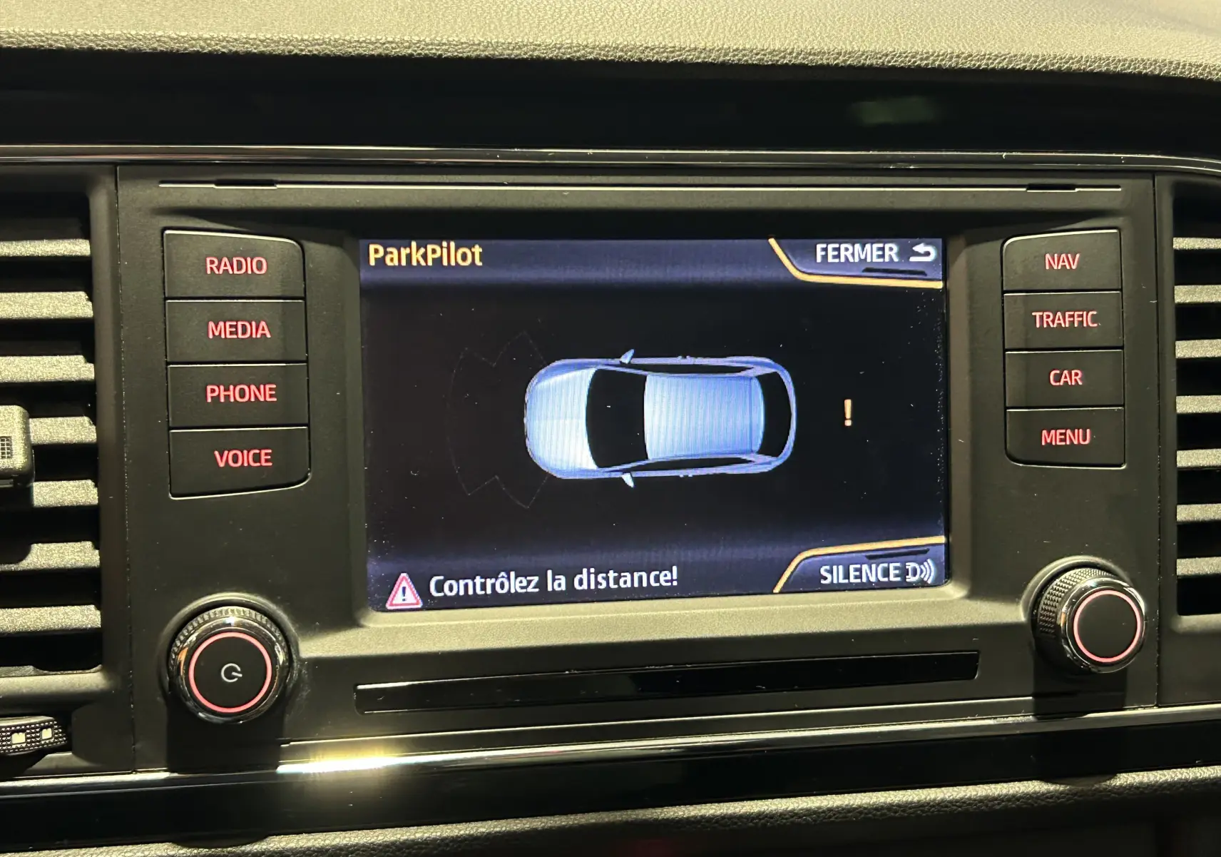 Écran central du système ParkPilot de la SEAT Leon 2014, affichant l'alerte de distance en mode radar avant et arrière.