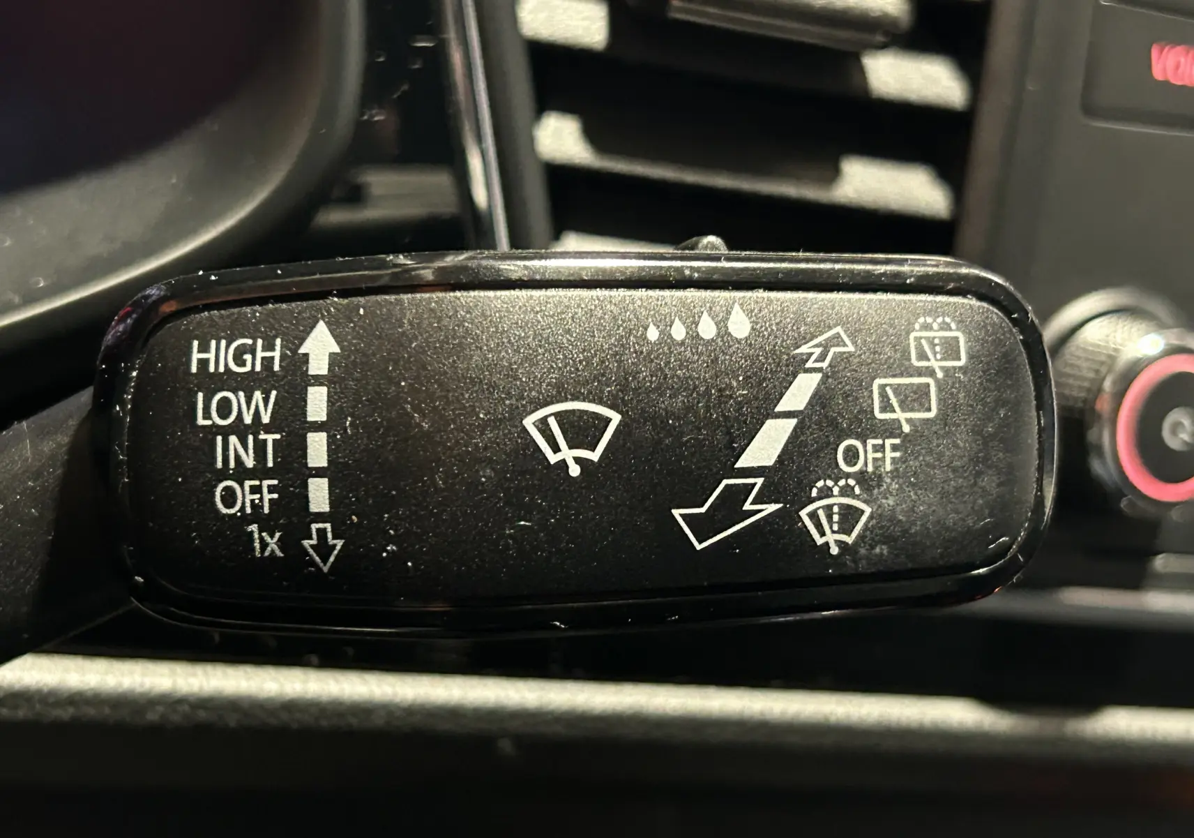Gros plan sur la manette d'essuie-glace noire du tableau de bord d'une SEAT LEON noire, version 2014.