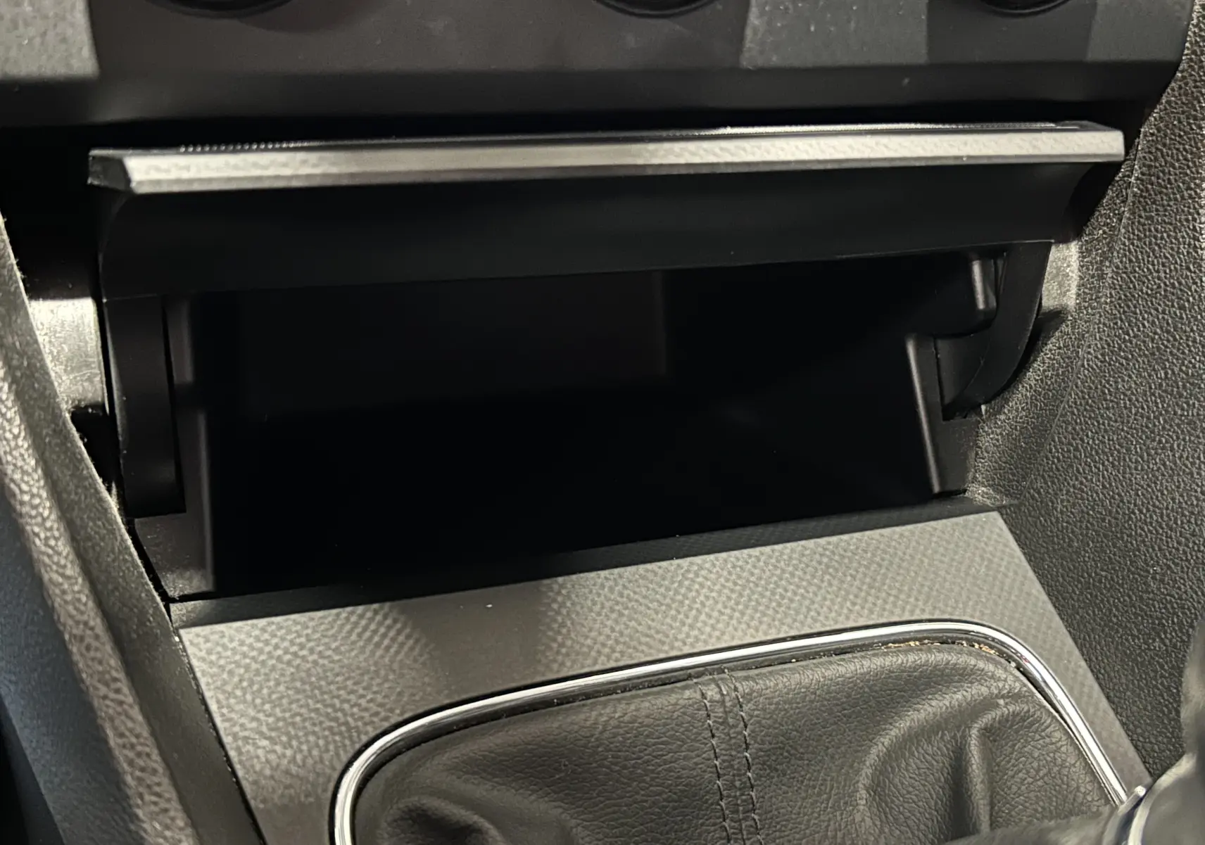 Gros plan sur la console centrale de la SEAT LEON 2014, mettant en valeur le soufflet de levier de vitesses en cuir noir.